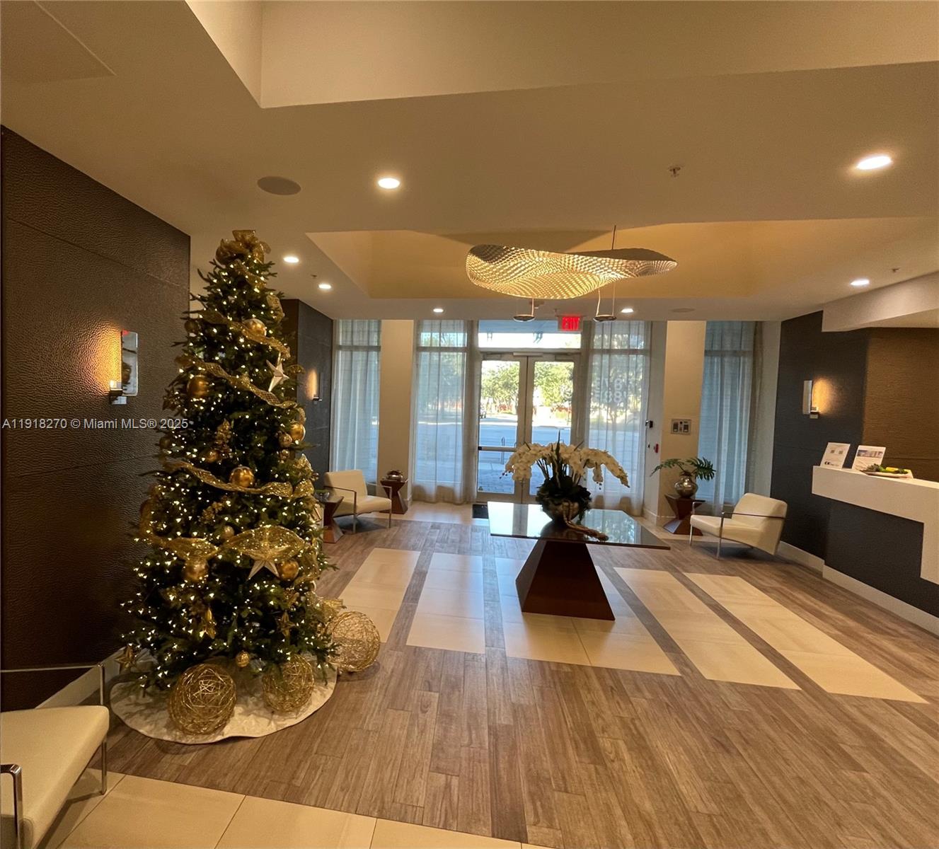 A modern lobby features a decorated Christmas tree, a central table, and white armchairs — 7875 NW 107th Ave # 514, Doral FL 33178, DORAL, FL