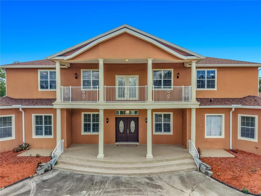 A two-story house with a stucco exterior, a front balcony, and a covered entryway — 6031 BANCROFT BOULEVARD, ORLANDO, FL