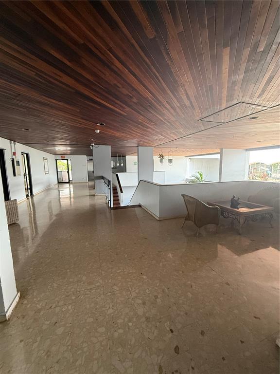 A spacious lobby features a wood-paneled ceiling, polished stone flooring, and a small seating area — . LAUREL UNIT 2306, SAN JUAN, PR