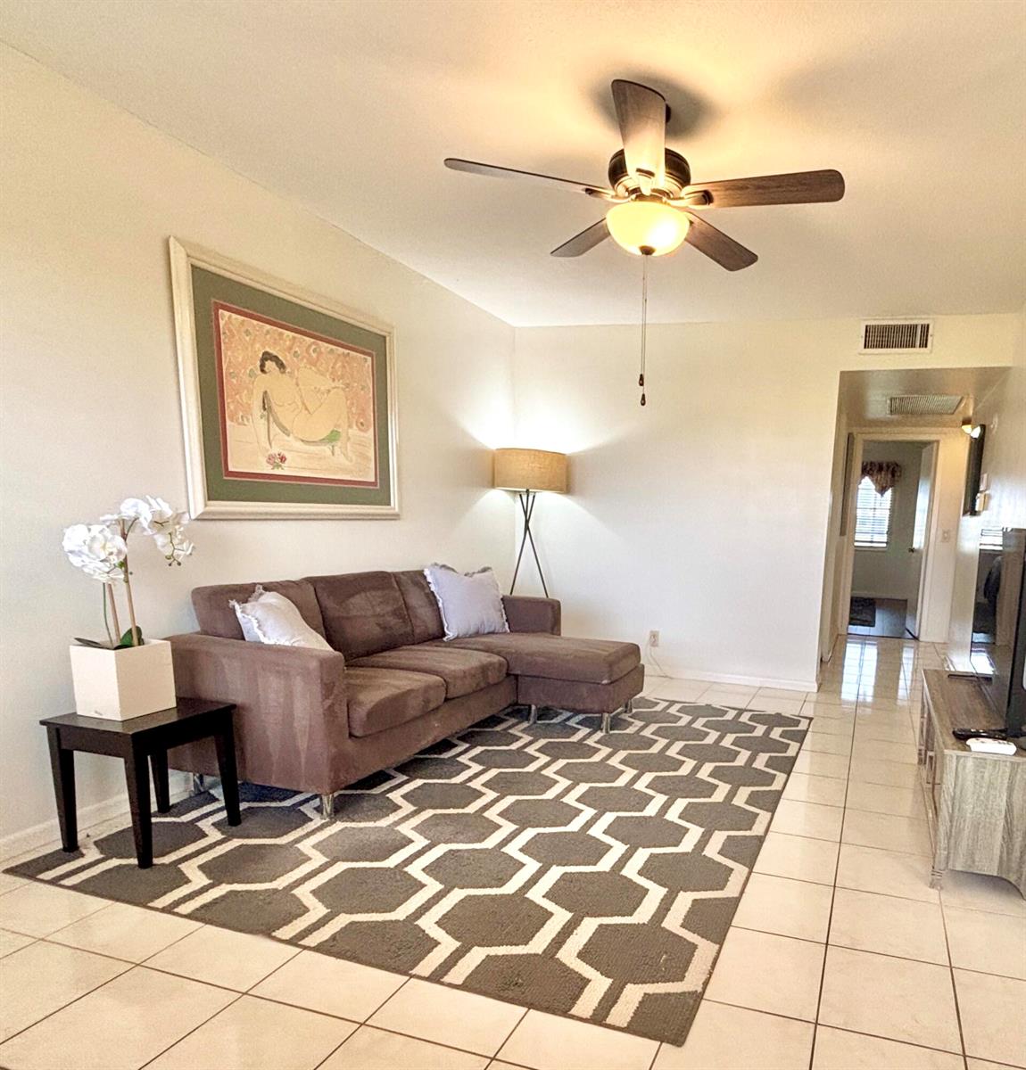 A living room features a brown sectional sofa, a geometric rug, and a ceiling fan — 4032 Newcastle B, Boca Raton FL 33434, BOCA RATON, FL