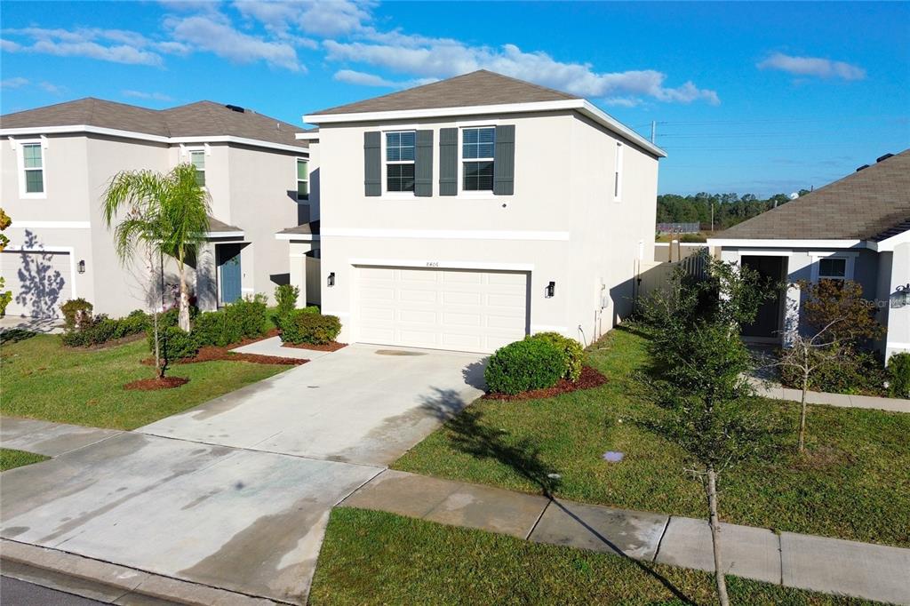 A two-story suburban house with a white exterior, a two-car garage, and a concrete driveway — 8406 HARDY BAY LOOP, WESLEY CHAPEL, FL