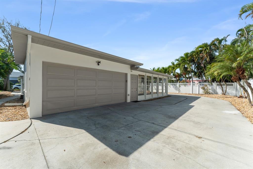 A modern kitchen features white cabinets, stainless steel appliances, and light wood-look flooring — 107 4TH STREET, BELLEAIR BEACH, FL