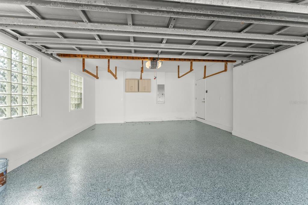 A kitchen with white cabinets, stainless steel appliances, and a laundry area to the left — 107 4TH STREET, BELLEAIR BEACH, FL
