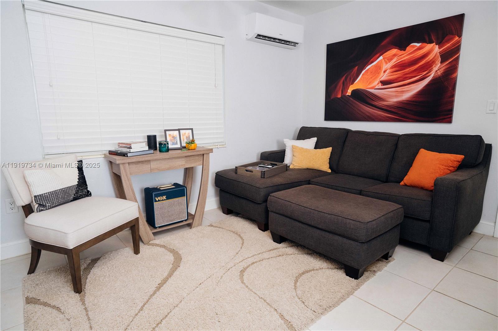 A living room features a dark sectional sofa, a beige rug, and a wooden console table — 7901 SW 64th Ave # 6, South Miami FL 33143, SOUTH MIAMI, FL