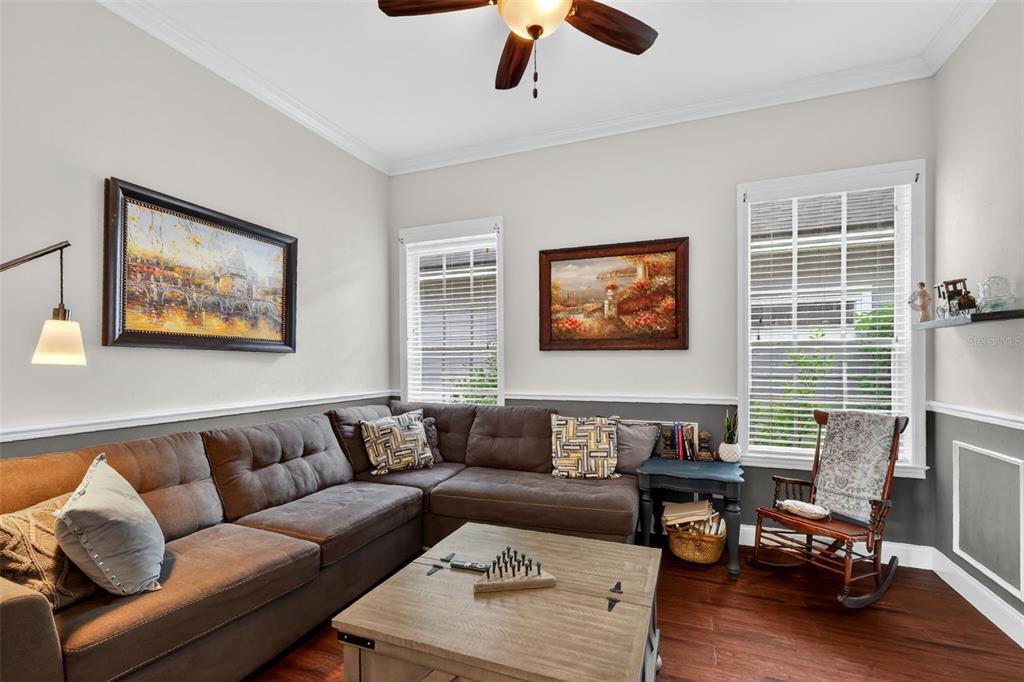 A living room features a brown sectional sofa, a wooden coffee table, and a rocking chair — 5108 SW 103RD WAY, GAINESVILLE, FL