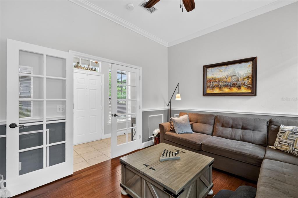 A living room features a brown sectional sofa, a wooden coffee table, and French doors — 5108 SW 103RD WAY, GAINESVILLE, FL