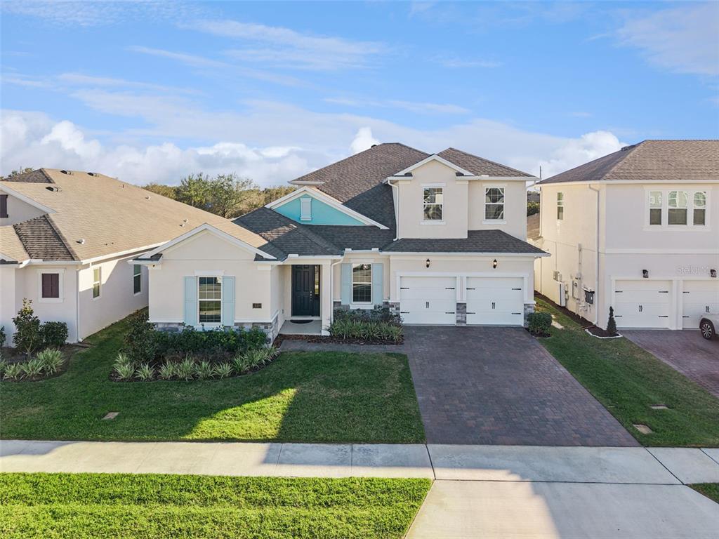 A two-story suburban house with a two-car garage, stone accents, and a paved driveway — 19334 BANFIELD PLACE, ORLANDO, FL