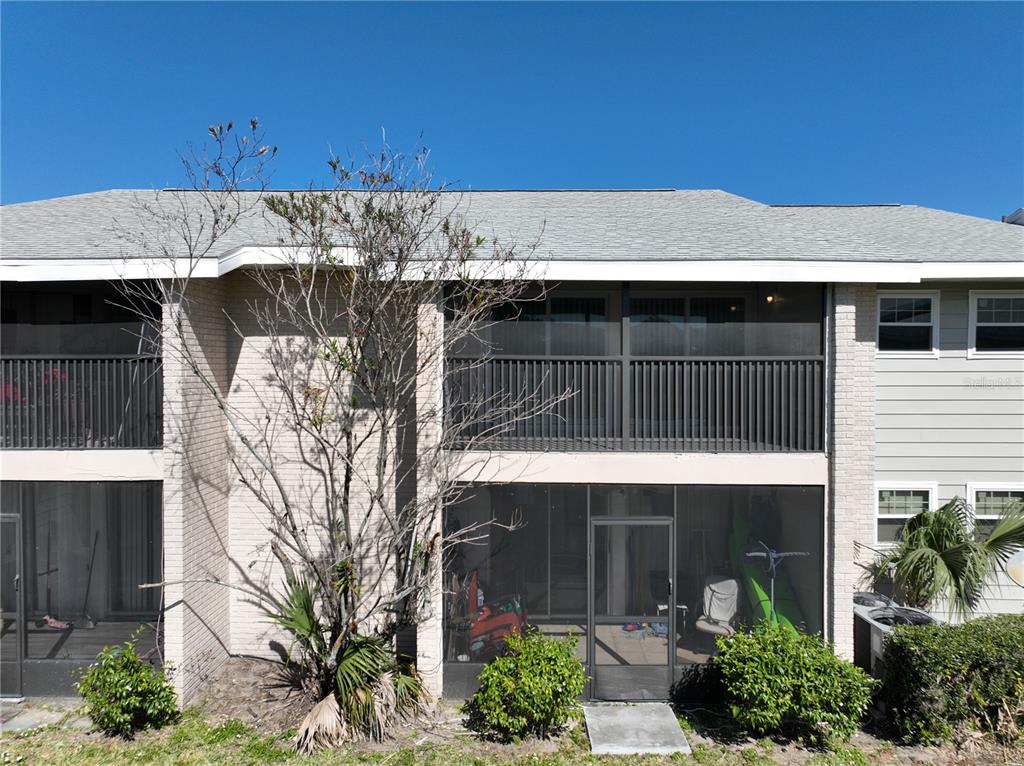 A two-story building features screened-in balconies and patios with brick and siding exterior walls — 802 SKY LAKE CIRCLE UNIT C, ORLANDO, FL