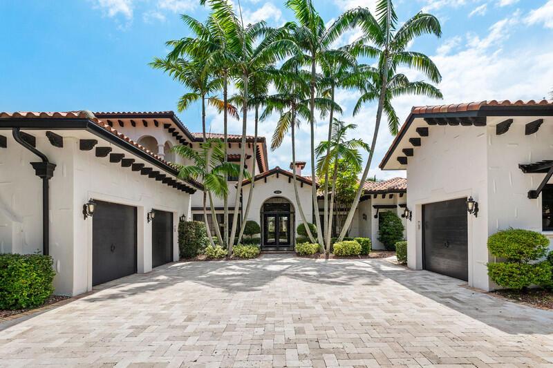 A white stucco house with a tiled roof features a paved courtyard and palm trees — 6680 NW 122nd Avenue, Parkland FL 33076, PARKLAND, FL