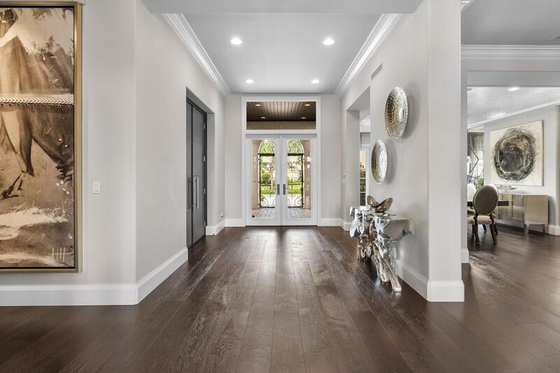 A bright foyer features dark hardwood floors, white walls, and a double-door entryway — 6680 NW 122nd Avenue, Parkland FL 33076, PARKLAND, FL