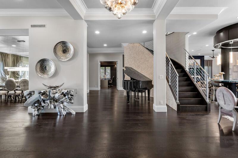 A grand foyer features dark hardwood floors, a black grand piano, and a curved staircase — 6680 NW 122nd Avenue, Parkland FL 33076, PARKLAND, FL