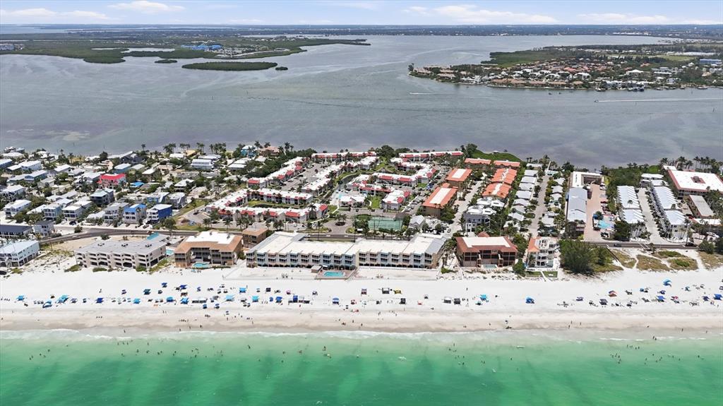 An aerial view of a beach resort with multiple buildings, swimming pools, and sandy shores — 1801 GULF DRIVE N UNIT 277, BRADENTON BEACH, FL