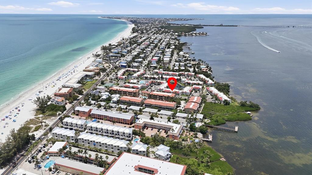 An aerial view shows a coastal resort complex situated between a beach and a bay — 1801 GULF DRIVE N UNIT 277, BRADENTON BEACH, FL