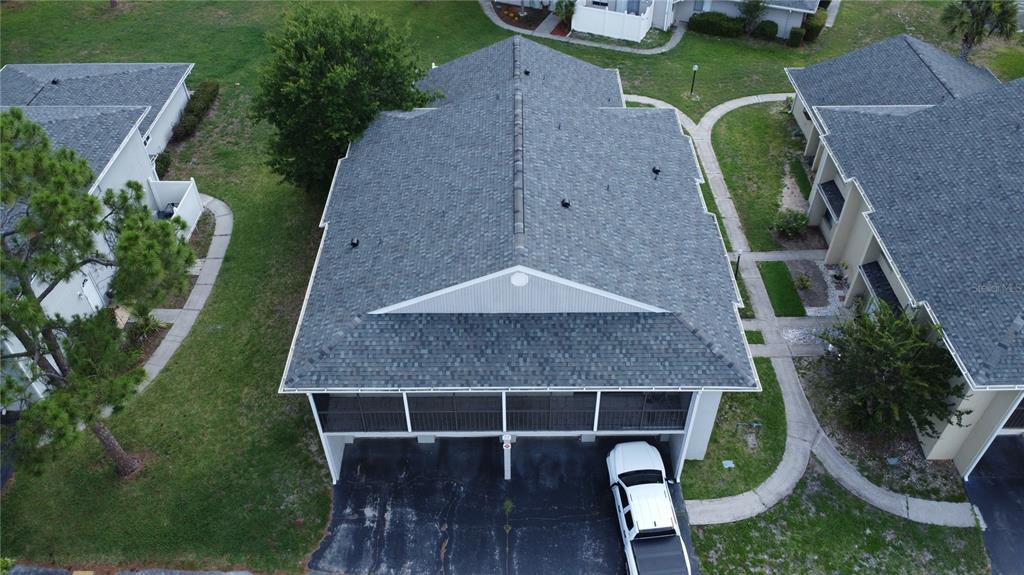 An aerial view of a multi-unit residential building with a gray shingled roof and carport — 4323 PINEBARK AVENUE UNIT 77-1, ORLANDO, FL
