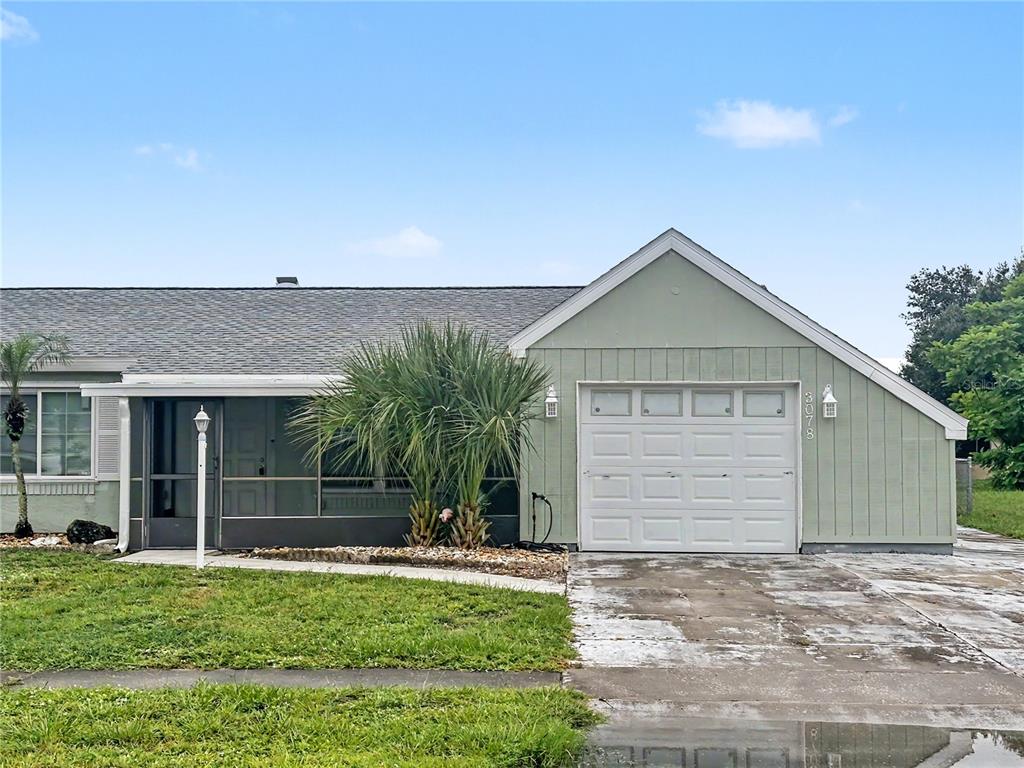 A single-story house with a green exterior, a white garage door, and a screened-in porch — 3078 GREENDALE ROAD, NORTH PORT, FL