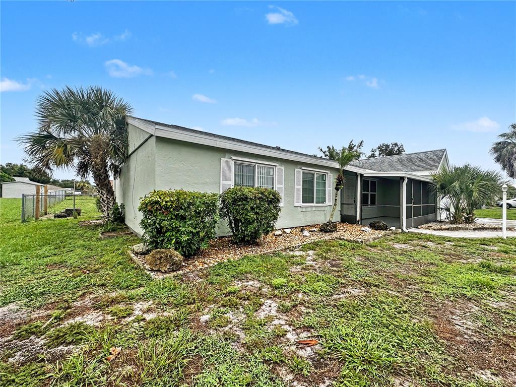 A light green single-story house with a screened porch and a palm tree in front — 3078 GREENDALE ROAD, NORTH PORT, FL