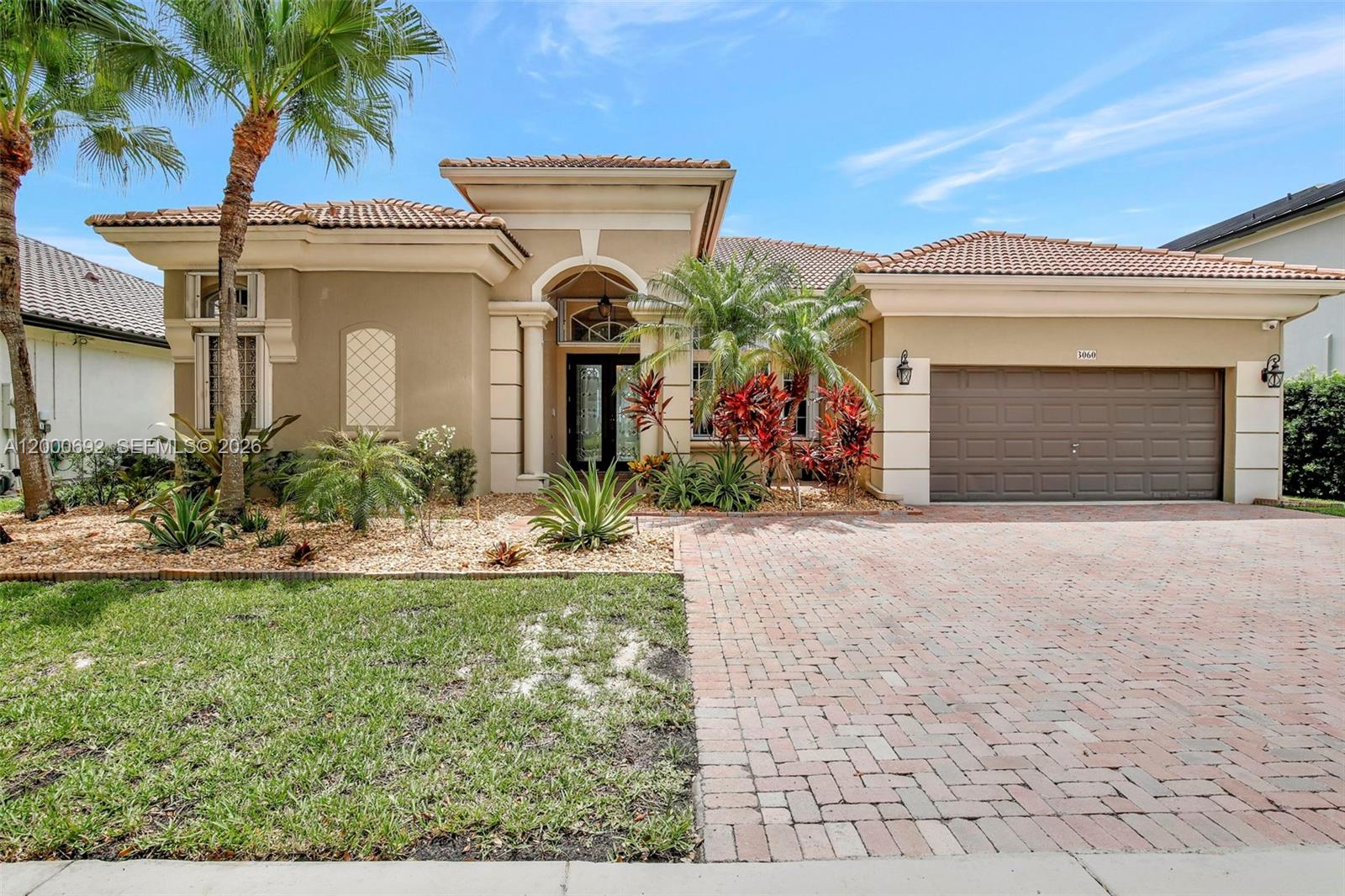 A single-story house with a tiled roof, brick driveway, and tropical landscaping in the front — 3060 SW 195th Ter, Miramar FL 33029, MIRAMAR, FL