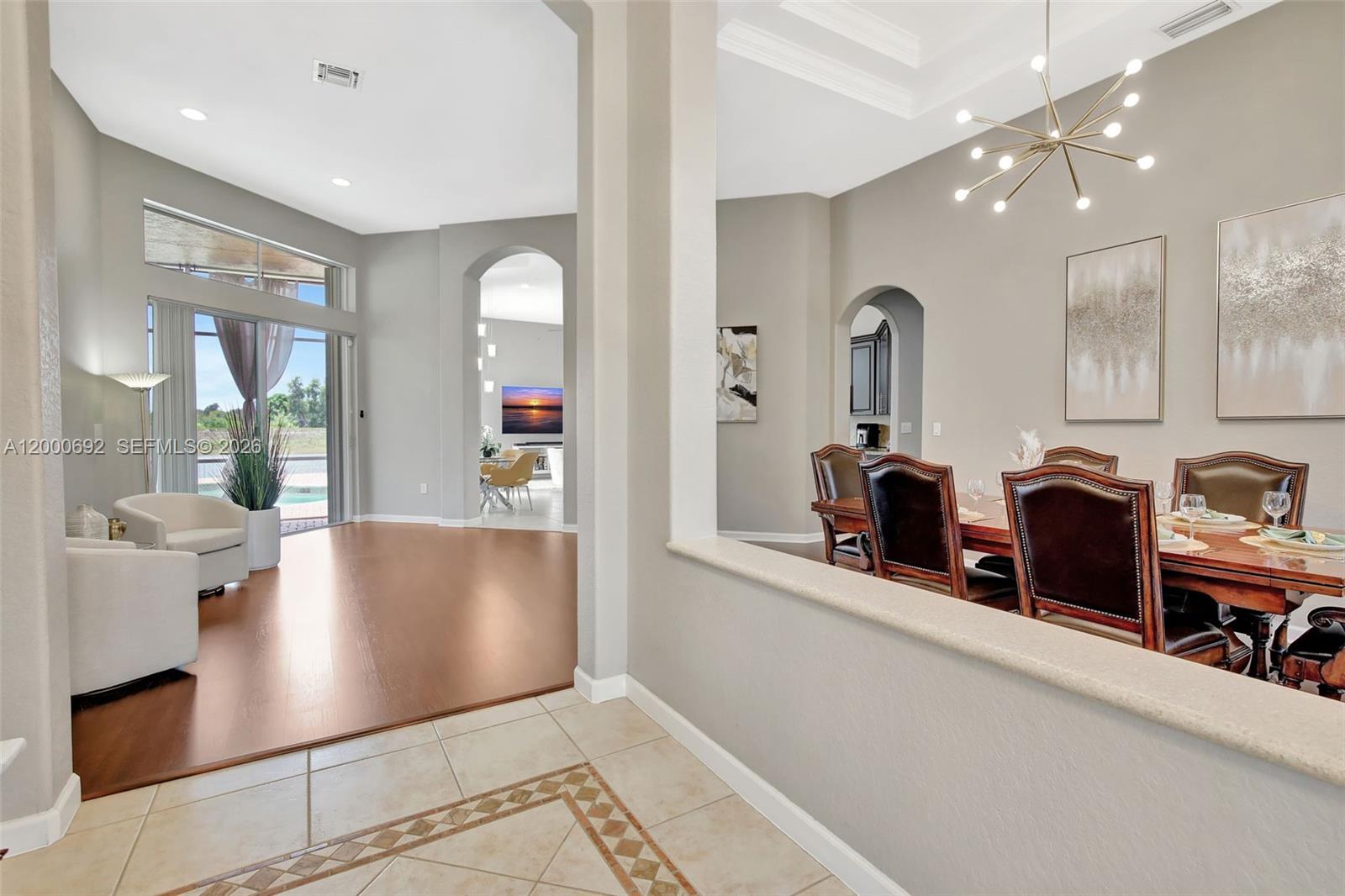 A dining room and living area feature tile and wood flooring with arched doorways — 3060 SW 195th Ter, Miramar FL 33029, MIRAMAR, FL