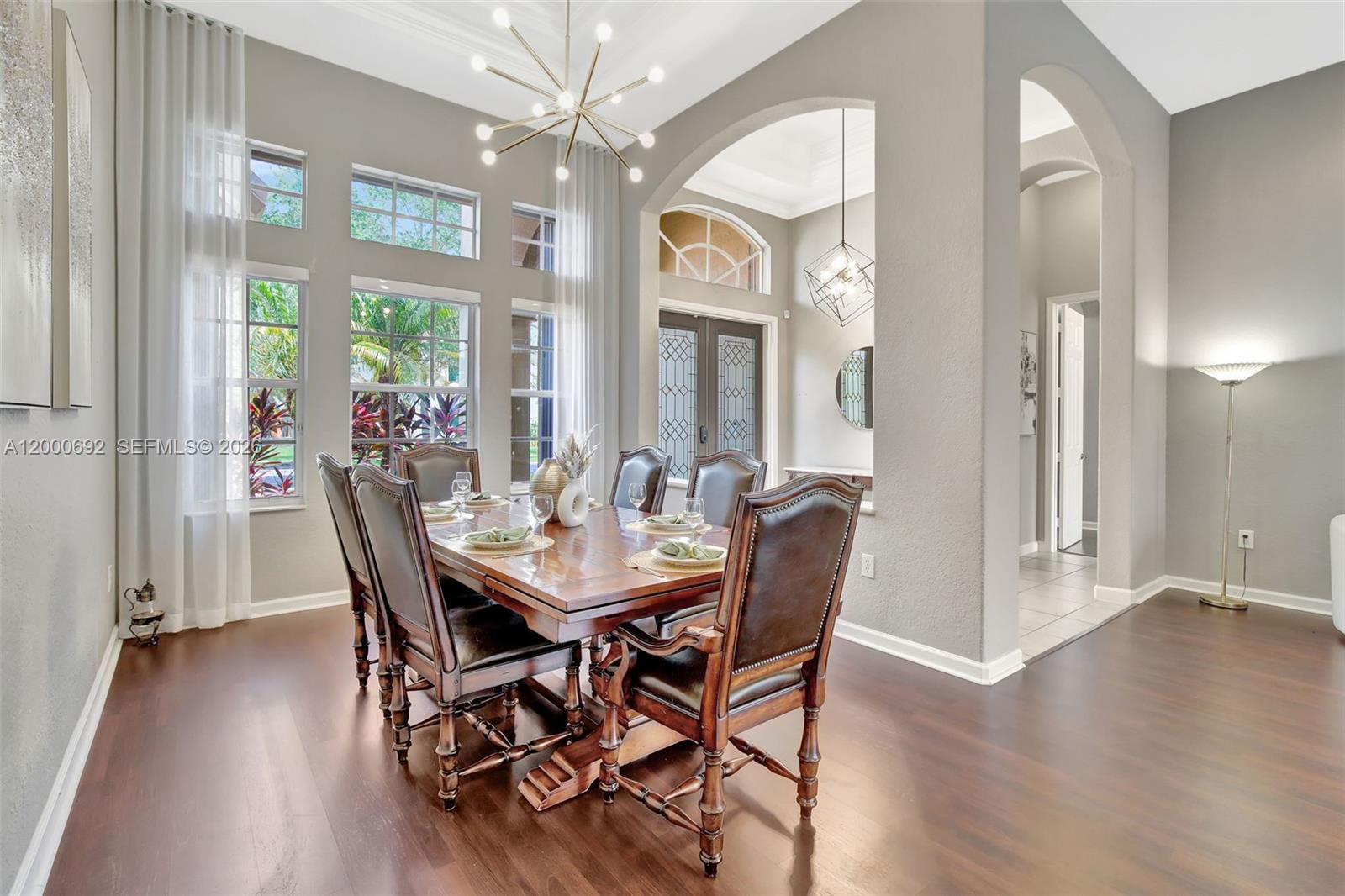 A formal dining room features a wooden table, leather chairs, and a modern chandelier — 3060 SW 195th Ter, Miramar FL 33029, MIRAMAR, FL
