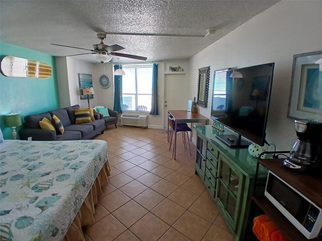 A studio apartment features a bed, a sofa, a dining table, and a television console — 313 S ATLANTIC AVENUE UNIT 5160, DAYTONA BEACH, FL