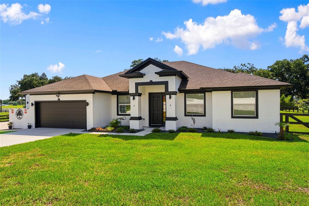 A single-story house with white stucco walls, black trim, and a dark shingled roof — 437 GANDY CEMETERY ROAD, BARTOW, FL