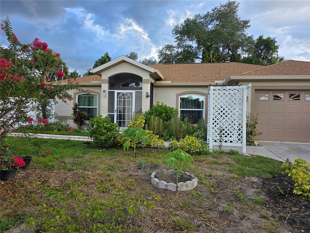 A single-story house with a tan exterior, a brown shingled roof, and a front garage — 4943 BECKHAM COURT, NORTH PORT, FL