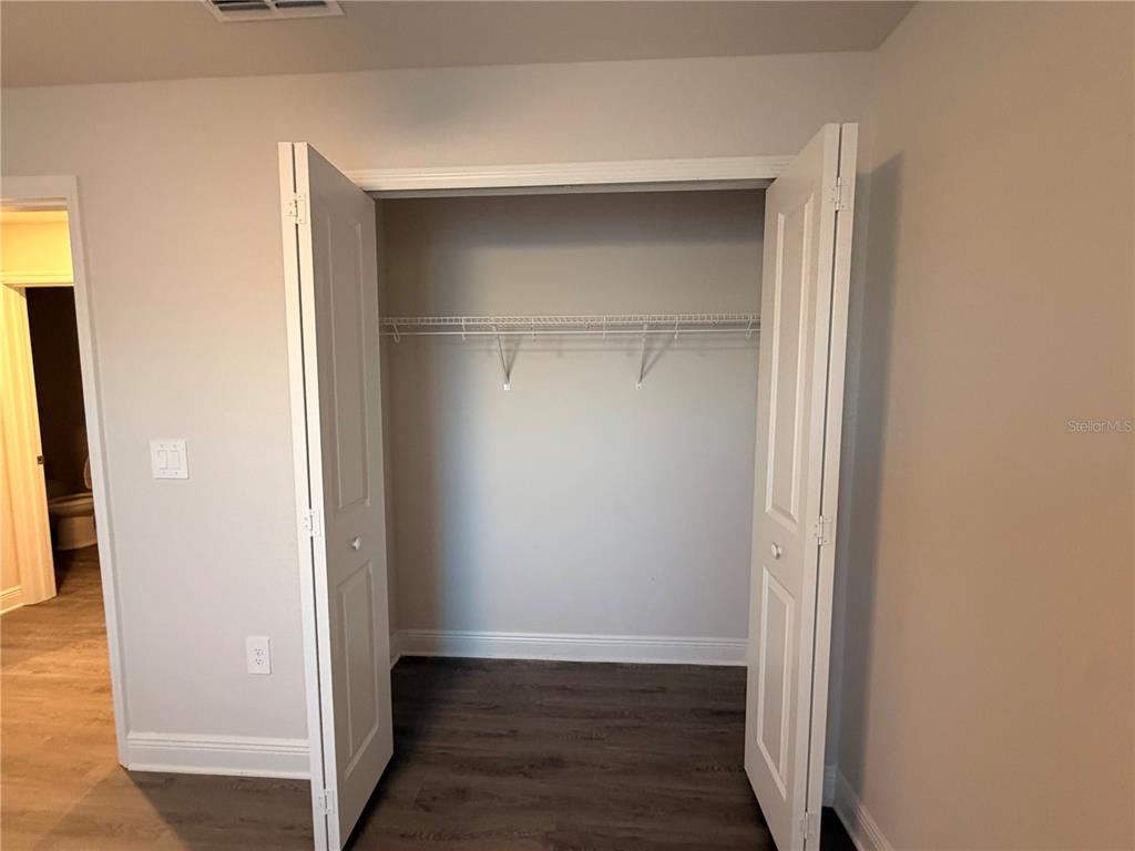 An open closet with a wire shelf is set against a light-colored wall — 445 ALVINA AVENUE, LAKE WALES, FL