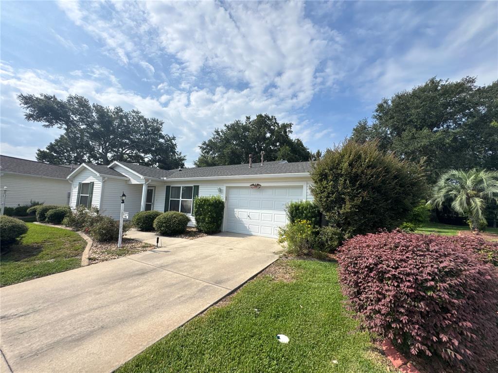 A single-story house with white siding, a concrete driveway, and a one-car garage — 17481 SE 76TH FLINTLOCK TERRACE, THE VILLAGES, FL