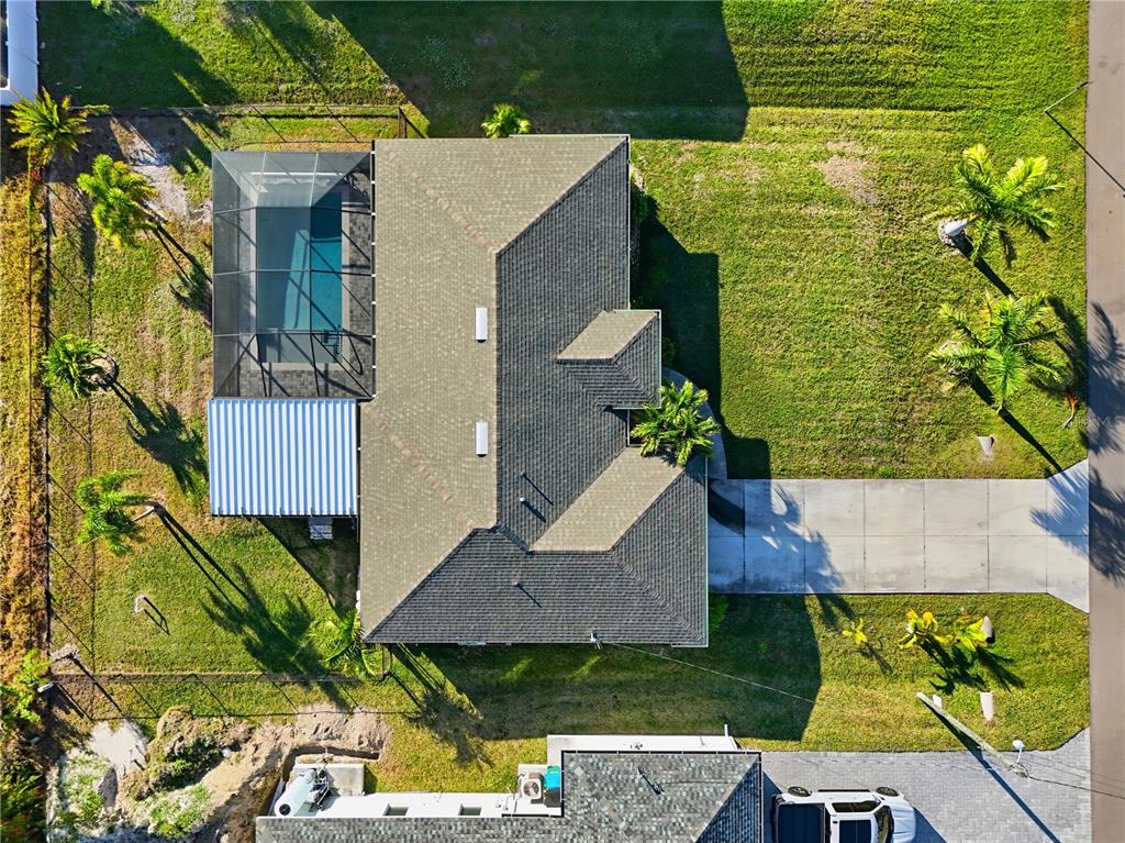 An aerial view shows a house with a pool, screened lanai, and a large yard — 2714 NW 22ND TERRACE, CAPE CORAL, FL