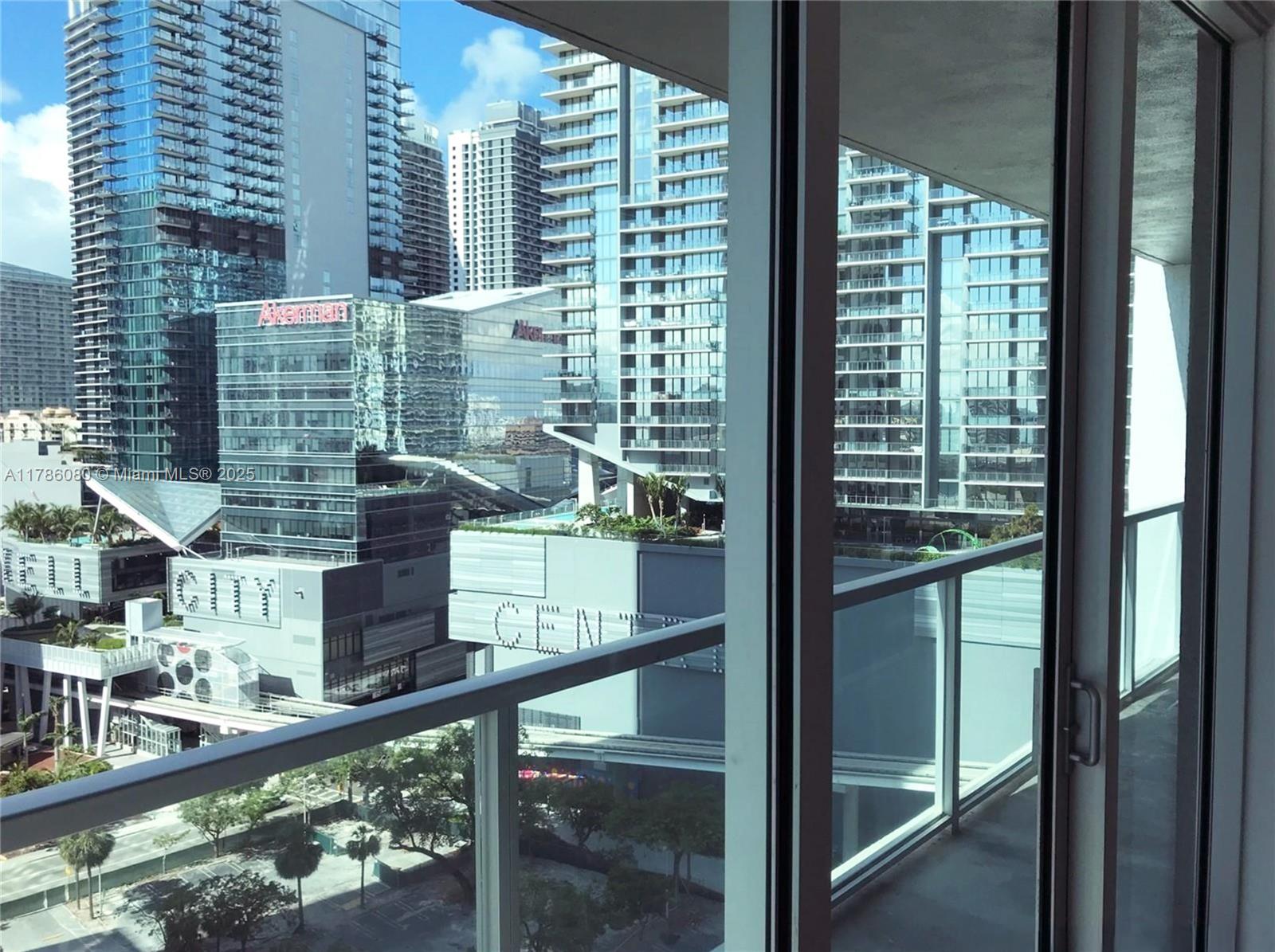 A balcony view overlooks a dense urban cityscape with modern high-rise buildings and a shopping center — 55 SE 6th St # 1610, Miami FL 33131, MIAMI, FL