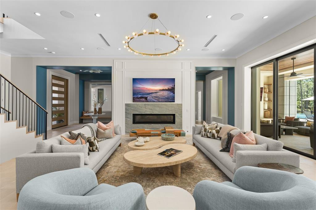 A living room features two sofas, two armchairs, a fireplace, and a circular chandelier — 8506 LAKE NONA SHORE DR, ORLANDO, FL