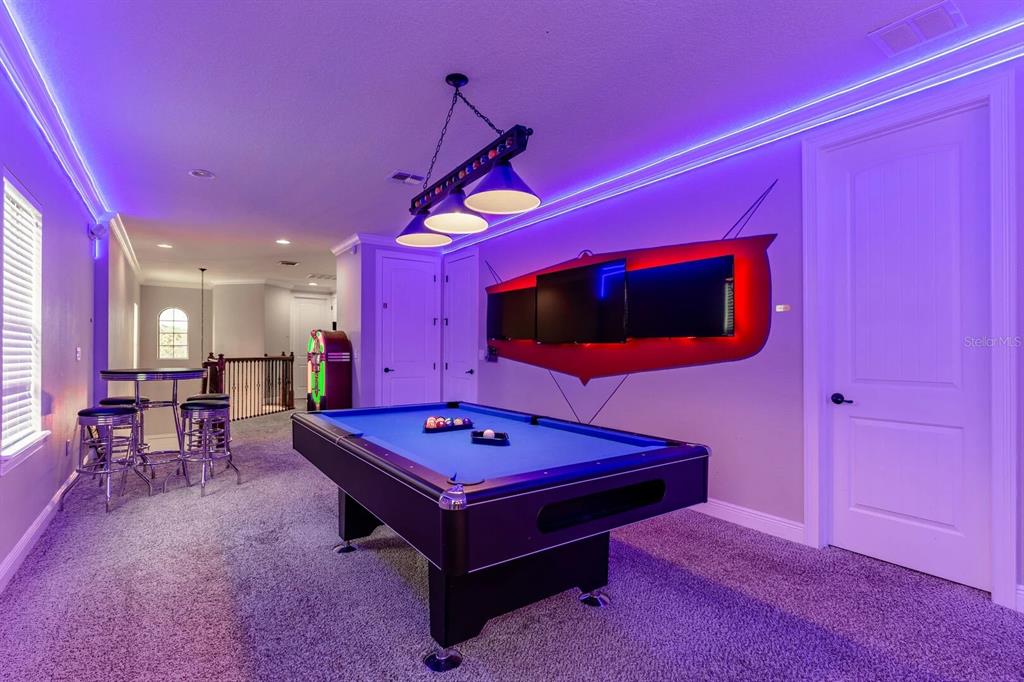 A dining room features a wooden table with a bench, upholstered chairs, and two pendant lights — 717 DESERT MOUNTAIN COURT, REUNION, FL