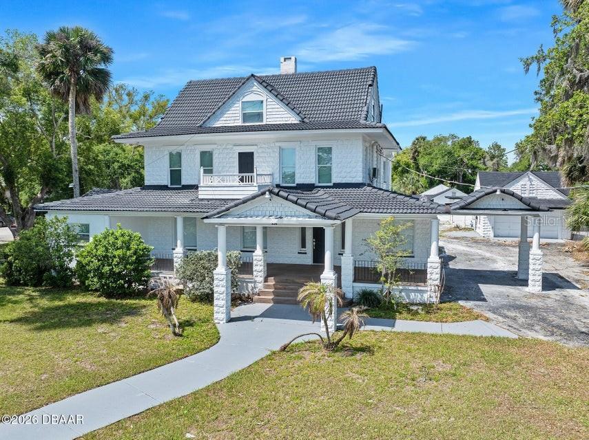 A two-story white house with a dark tiled roof and a front porch — 934 S RIDGEWOOD AVENUE, DAYTONA BEACH, FL