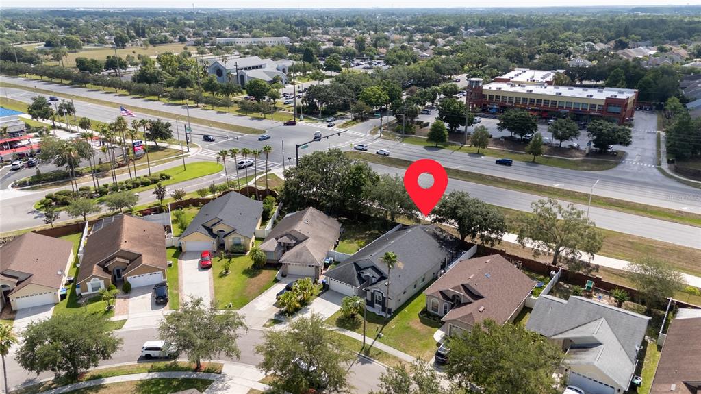 An aerial view shows a suburban neighborhood with houses situated near a multi-lane road — 12868 GETTYSBURG CIRCLE, ORLANDO, FL