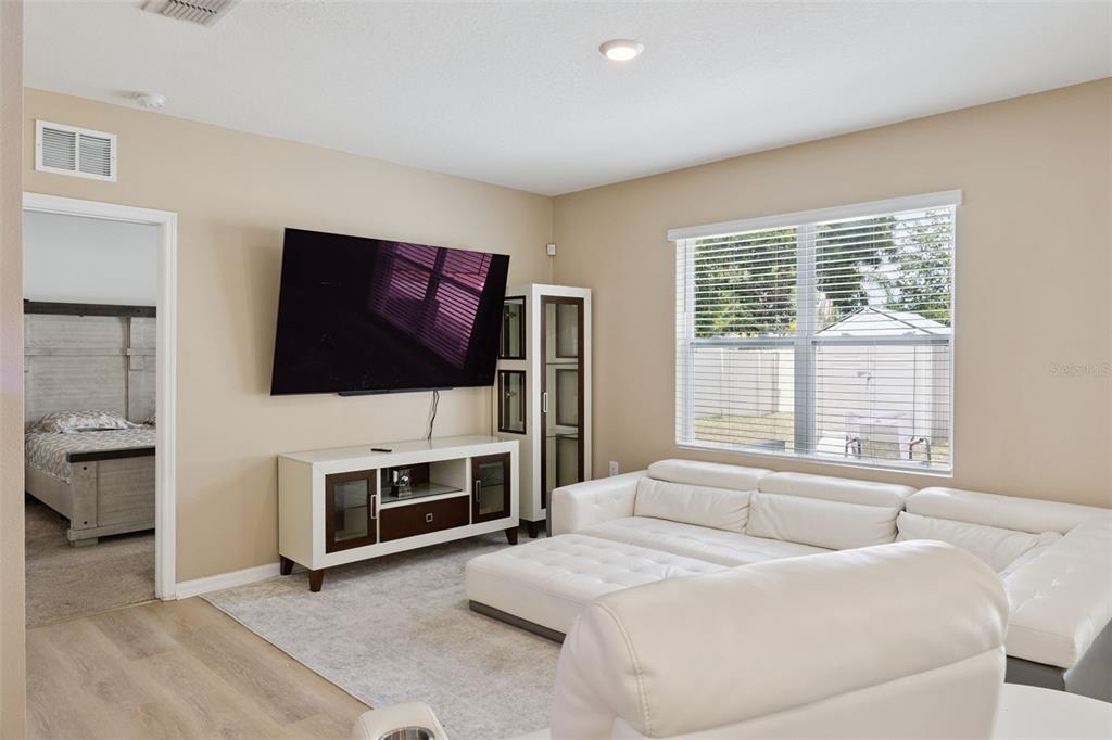 A living room features a white sectional sofa, a television, and a media console — 511 JACKS WAY, DAVENPORT, FL