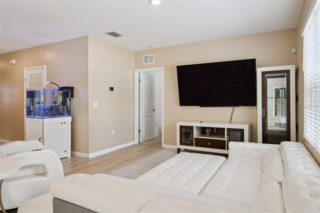 A living room features a white sectional sofa, a wall-mounted television, and a fish tank — 511 JACKS WAY, DAVENPORT, FL
