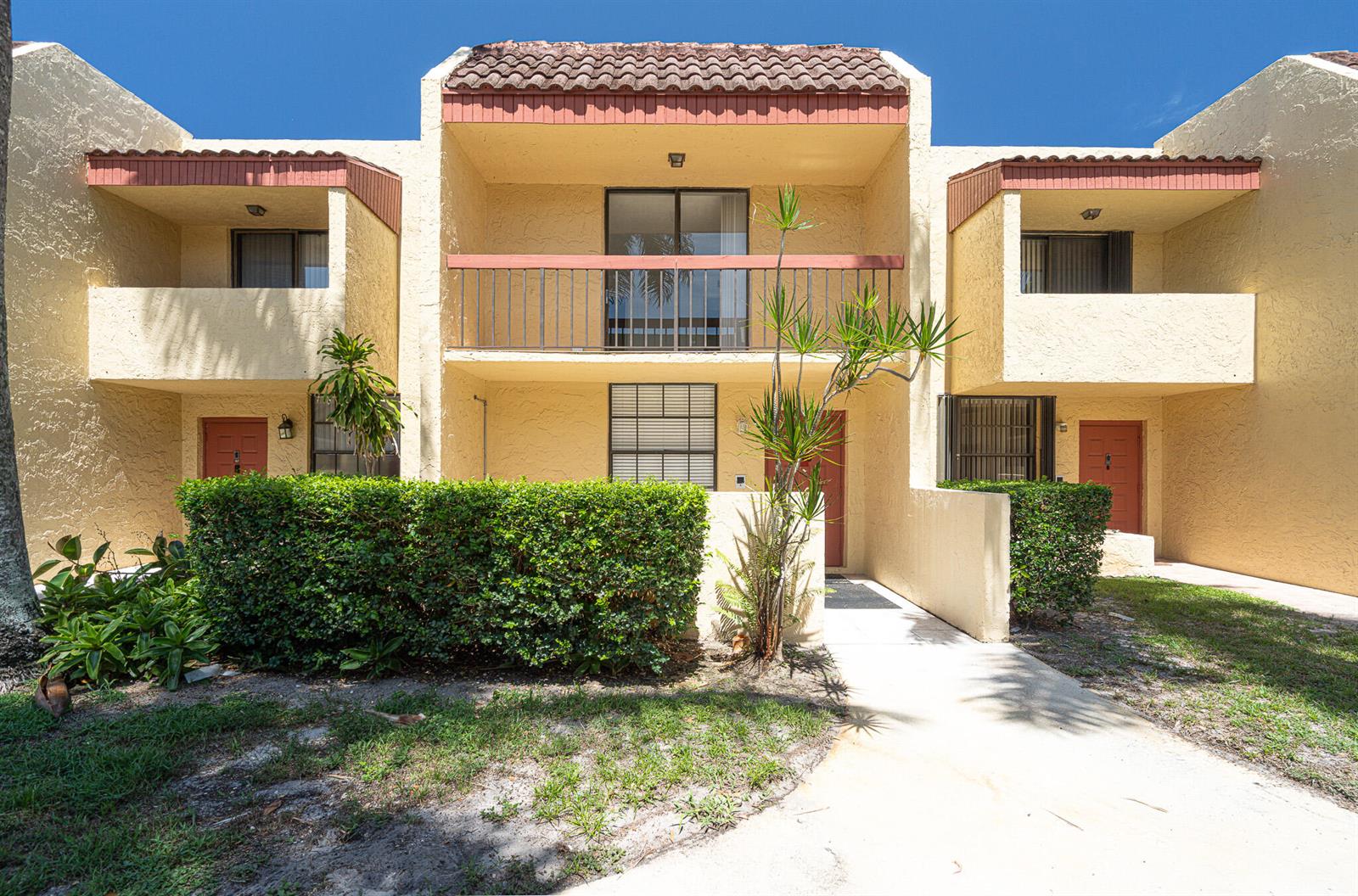 A two-story yellow stucco townhouse with a tiled roof, balconies, and a landscaped front yard — 769 SE 1st Way # 85, Deerfield Beach FL 33441, DEERFIELD BEACH, FL