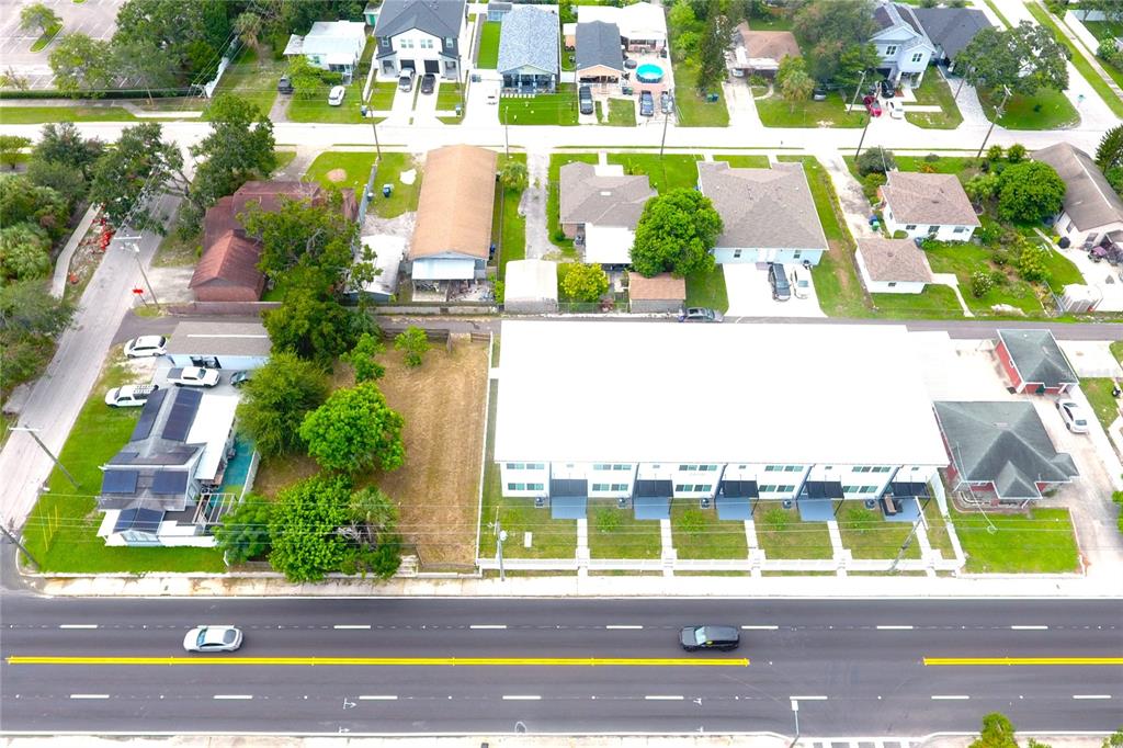 An aerial view shows a multi-unit residential building, a vacant lot, and surrounding neighborhood homes — 2606 W COLUMBUS DRIVE, TAMPA, FL