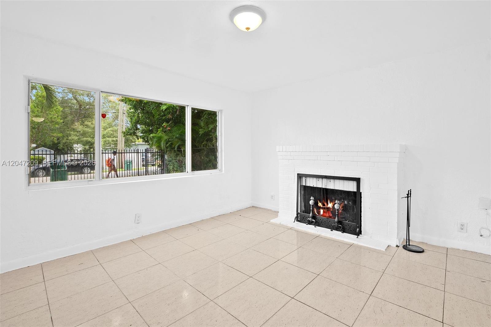A living room features white walls, tile flooring, and a white brick fireplace — MIAMI, FL