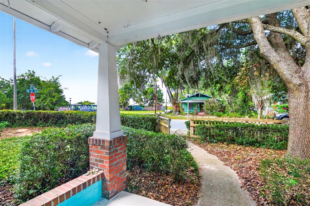 A view from a covered porch looking out toward a street, trees, and a house — 433 SE 7TH STREET, GAINESVILLE, FL