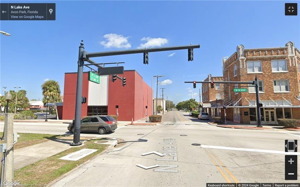 An exterior street-level view of an intersection in Avon Park, Florida, featuring traffic lights — 2 W Main Street, FL 33825, FL