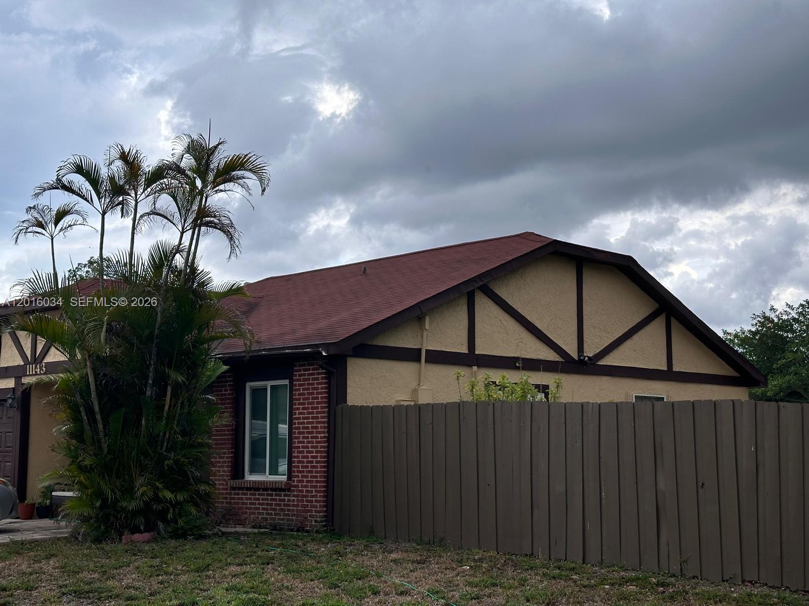 A single-story house with a brown garage and fence sits behind a grassy lawn — 11143 E Model Cir E, Boca Raton FL 33428, BOCA RATON, FL