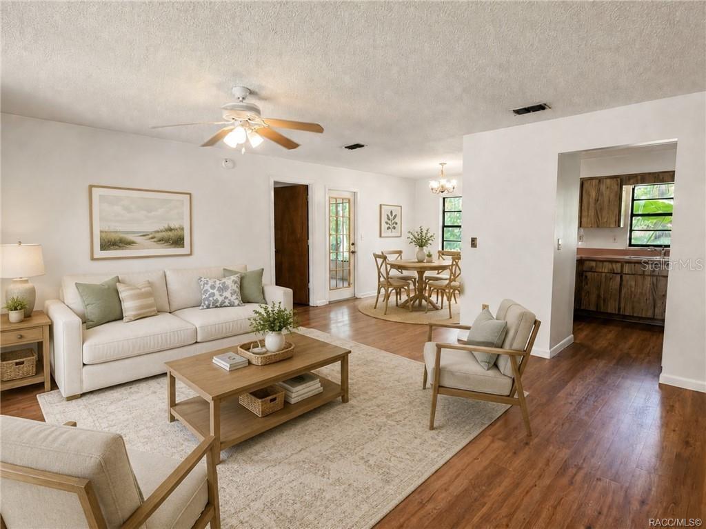 A living room with a white sofa, wooden coffee table, and an adjacent dining area — 3565 E PERRY STREET, INVERNESS, FL