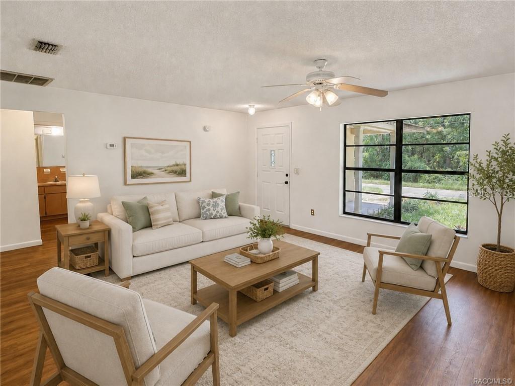 A living room features a white sofa, two armchairs, a coffee table, and a large window — 3565 E PERRY STREET, INVERNESS, FL