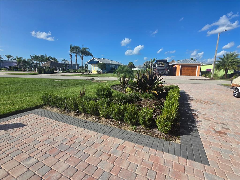 A landscaped garden bed sits between two paved driveways in front of suburban houses — 3063 WOOD DUCK DRIVE, POLK CITY, FL