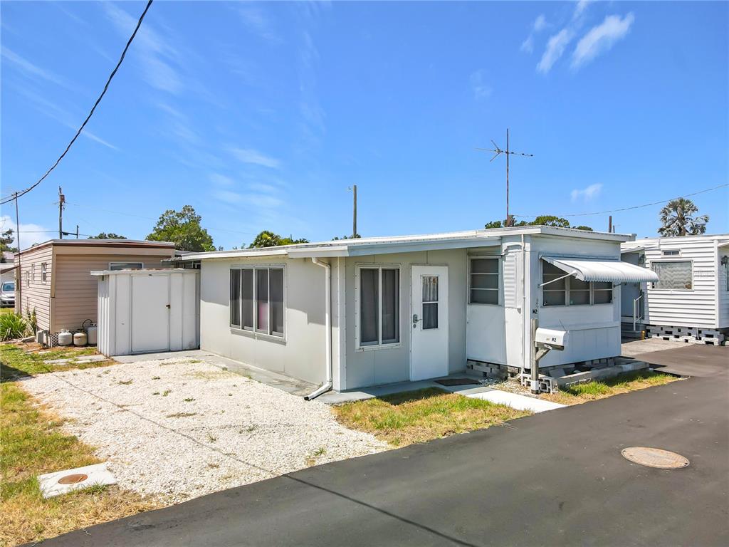 A single-story mobile home with a gravel driveway and a white storage shed — 12674 SEMINOLE BOULEVARD UNIT M2, LARGO, FL
