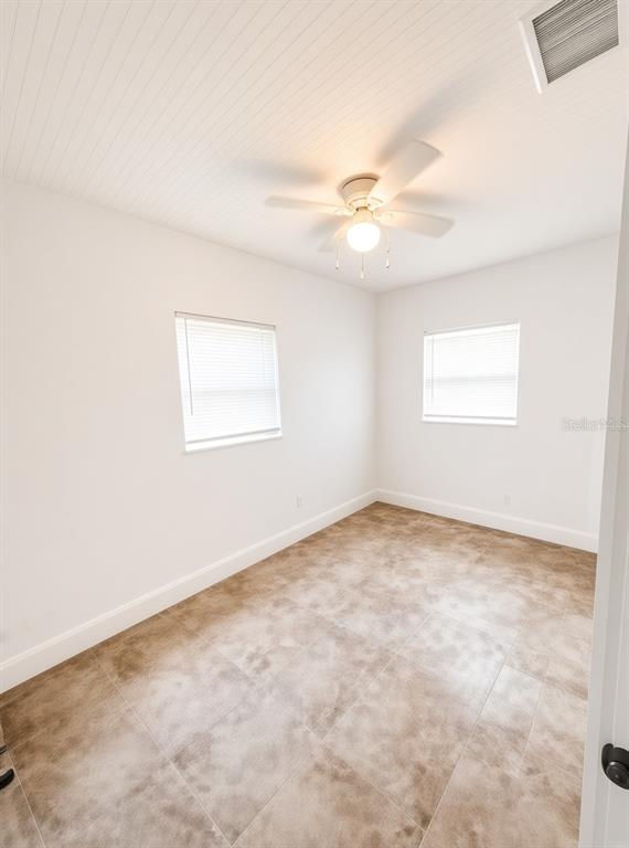 An empty room with white walls, a beadboard ceiling, a ceiling fan, and tiled flooring — 1125 13TH AVENUE S, ST PETERSBURG, FL