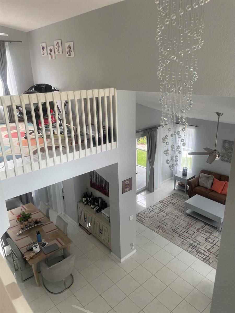 A high-angle view shows an open-concept living area with a dining room, loft, and chandelier — 4251 Pine Hollow Circle, FL 33463, FL
