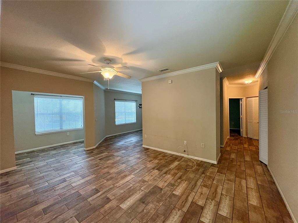 An interior view of a living area with wood-look tile flooring and a ceiling fan — 2171 PORTOFINO PLACE UNIT 2714, PALM HARBOR, FL