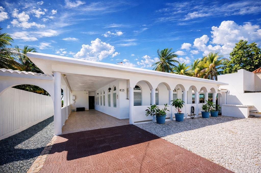 A white house exterior features a covered carport, arched windows, and a gravel driveway — STREET NO 3 KM 112 BO. GUARDARRAYA, PATILLAS, PR